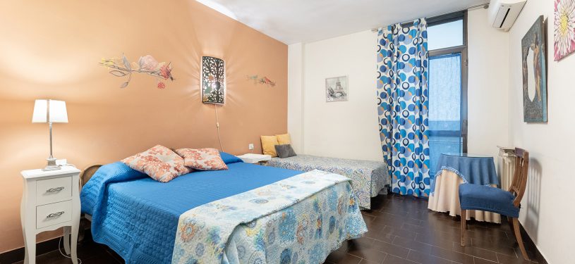 Habitación de dos camas, una doble de matrimonio, armario blanco empotrado